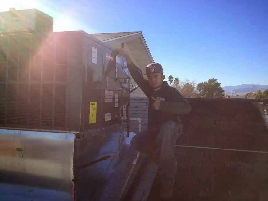 HVAC technician performing HVAC Inspection on a rooftop unit in Eloy
